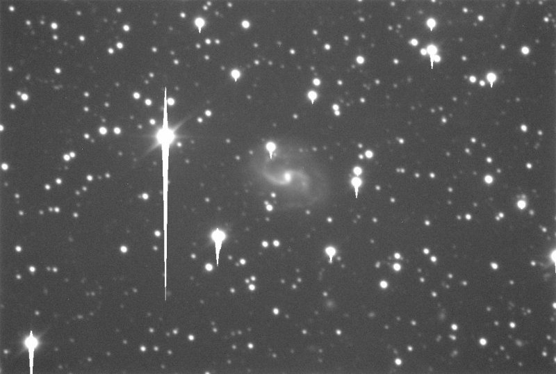 Galaxie IC1296 na testovacím snímku z fotometrické kamery Perkova dalekohledu, zatím bez barevných filtrů. Hvězdy v okolí galaxie jsou přeexponovány. Obraz nebyl nijak upravován, nijak redukován (nebyl proveden flat field, nebylo odečteno pozadí).