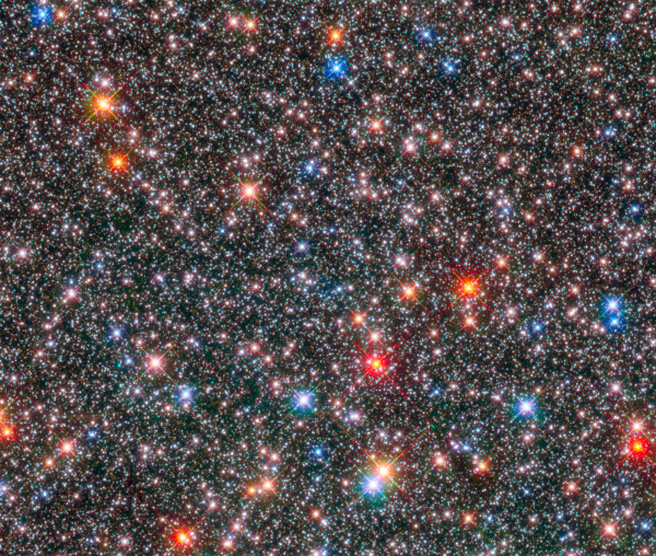 Hvězdy ve středu Mléčné dráhy na snímku pořízeném s pomocí Hubblova kosmického teleskopu. Oblast nacházející se ve vzdálenosti 26 000 světelných roků (8,1 kpc) byla zobrazena pomocí širokúhlé kamery sekvencí expozic v blízkém infračerveném a viditelném světle. Různé barvy hvězd vypovídají o různé teplotě panující na jejich povrchu. Podrobnější spektrum pak poskytuje informaci o chemickém složení a vývoji, kterým hvězdy v minulosti prošly (snímek: NASA/ESA/STScI).