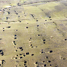 Aerial shot of coal mining field where numerous large depressions have formed over abandoned mines.