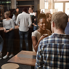 People mingle and chat in a coffee shop.