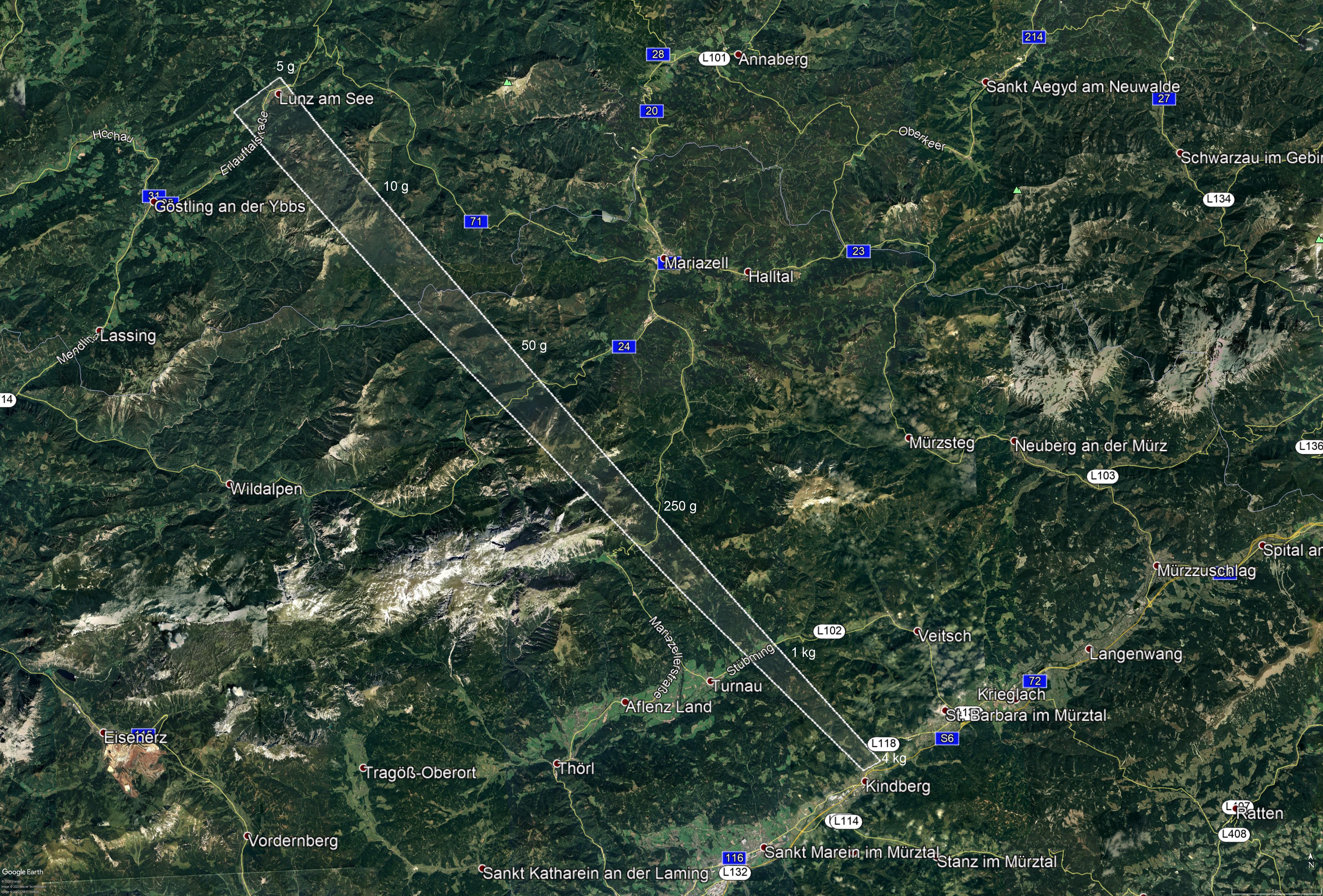 Obrázek 4. Mapa vypočtené pádové oblasti meteoritů (bílý lichoběžník). Oblast je 50 km dlouhá a až 3 km široká. Sever je nahoře. Očekáváme dva meteority o hmotnostech 1 - 4 kg v jihovýchodní části oblasti. Hmotnosti meteoritů budou klesat a jejich počet vzrůstat směrem na severozápad. Očekávané střední hmotnosti jsou uvedeny u pravého okraje vyznačené oblasti. Meteority různých hmotností však mohou být částečně pomíchané a v případě pozdních rozpadů se mohou malé meteority vyskytovat i v oblasti větších kusů.  (grafika: Astronomický ústav AV ČR, podkladová mapa: Google Earth)